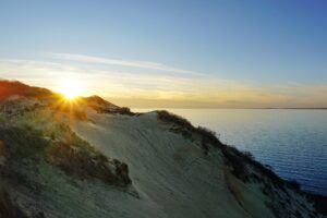 Sunrise over a coastal bank in Menemsha Hills, on Martha's Vineyard, with a view of the ocean