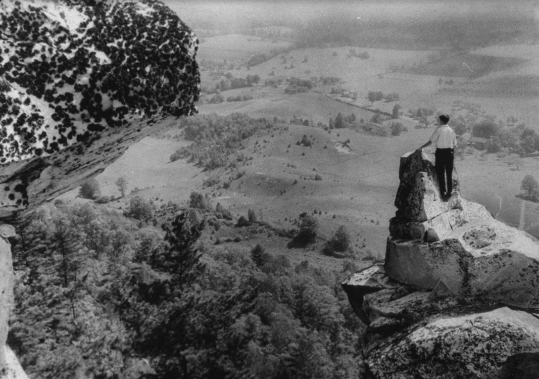 Man standing on the peak of Monument Mountain, historical B&W photo