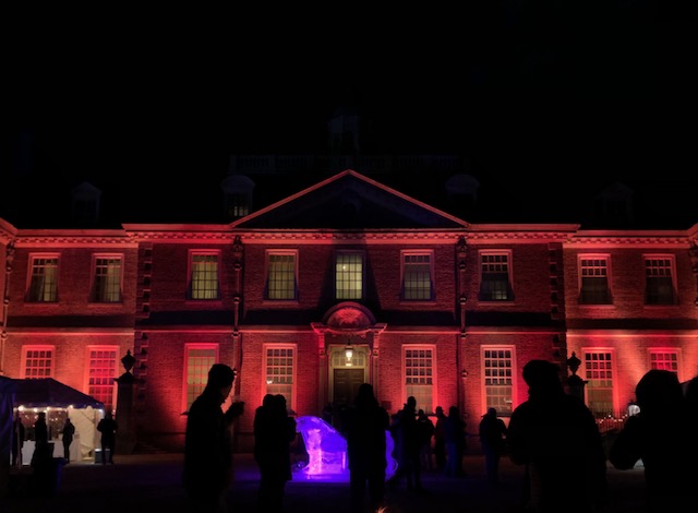 Castle Hill, lit up at night, appears bathed in a red glow against a dark night sky