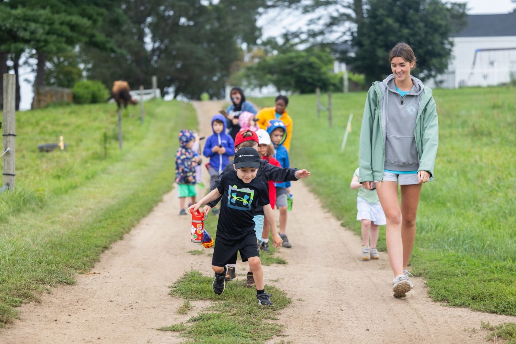 Children walking down a farm path with a counselor