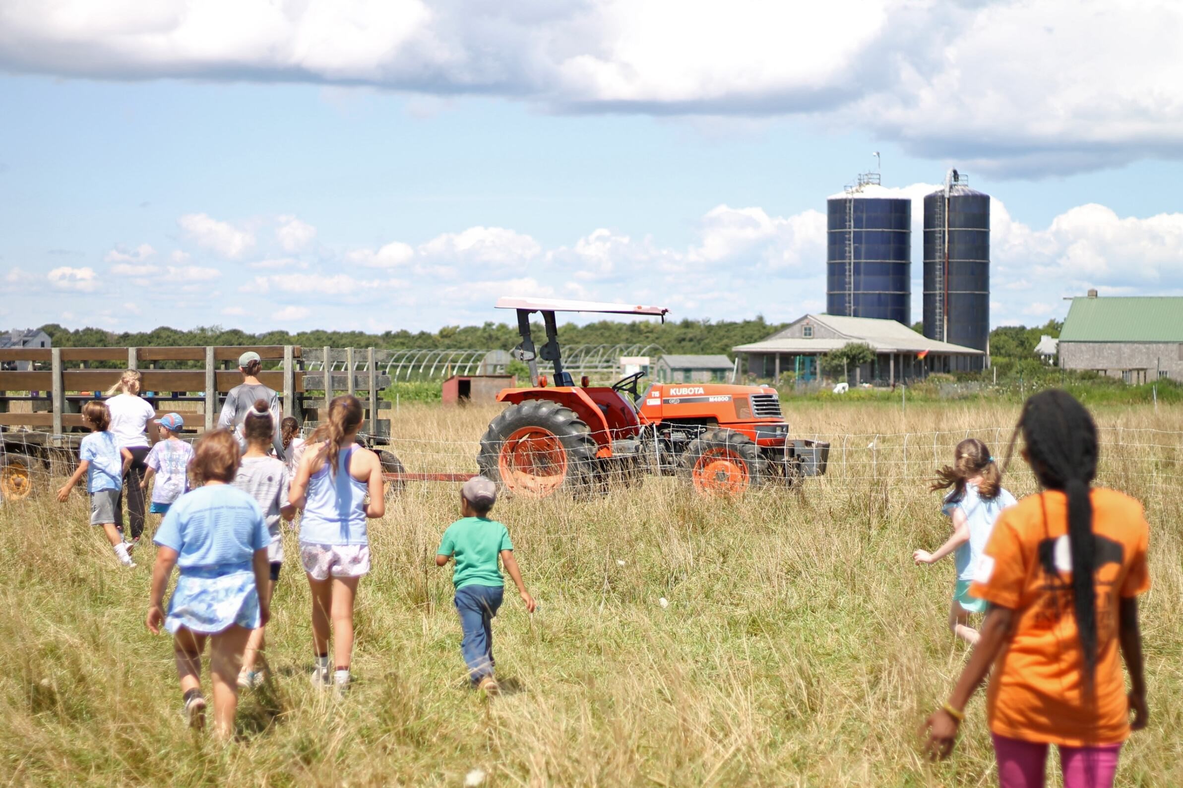 Campers stand near a tractor