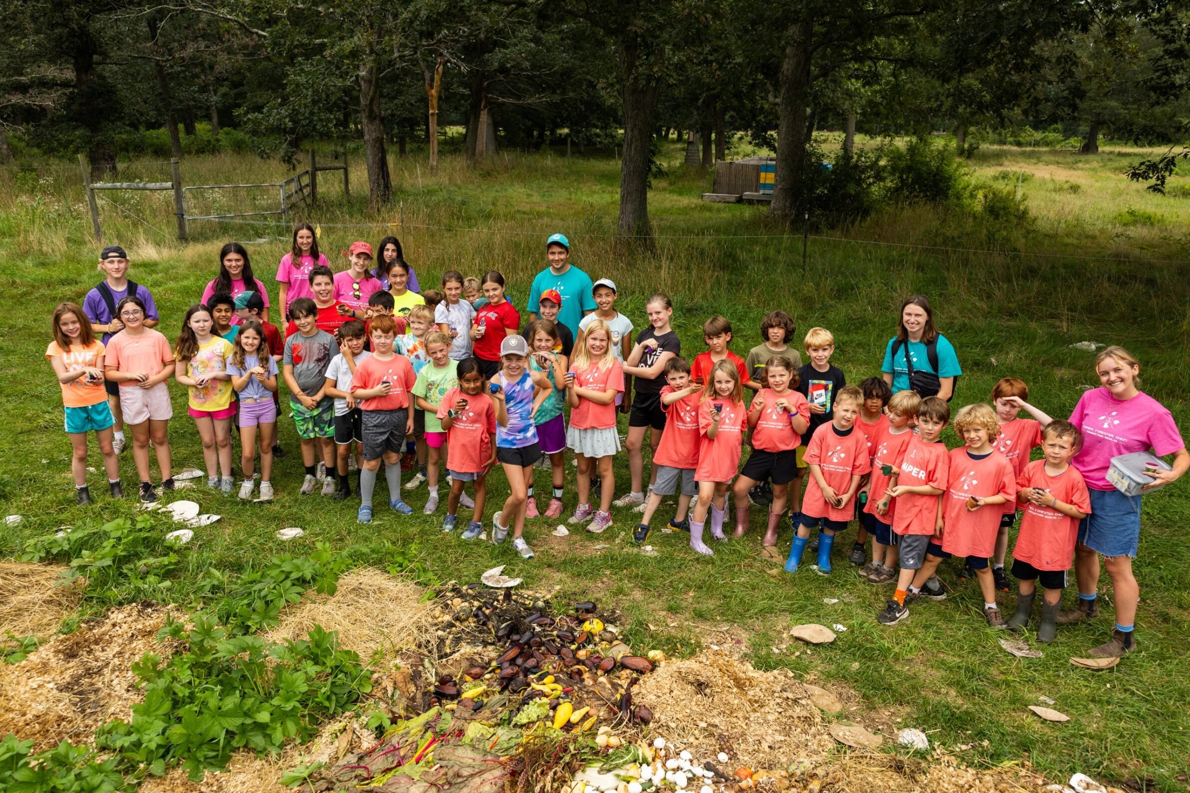 Campers pose next to a vegetable garden