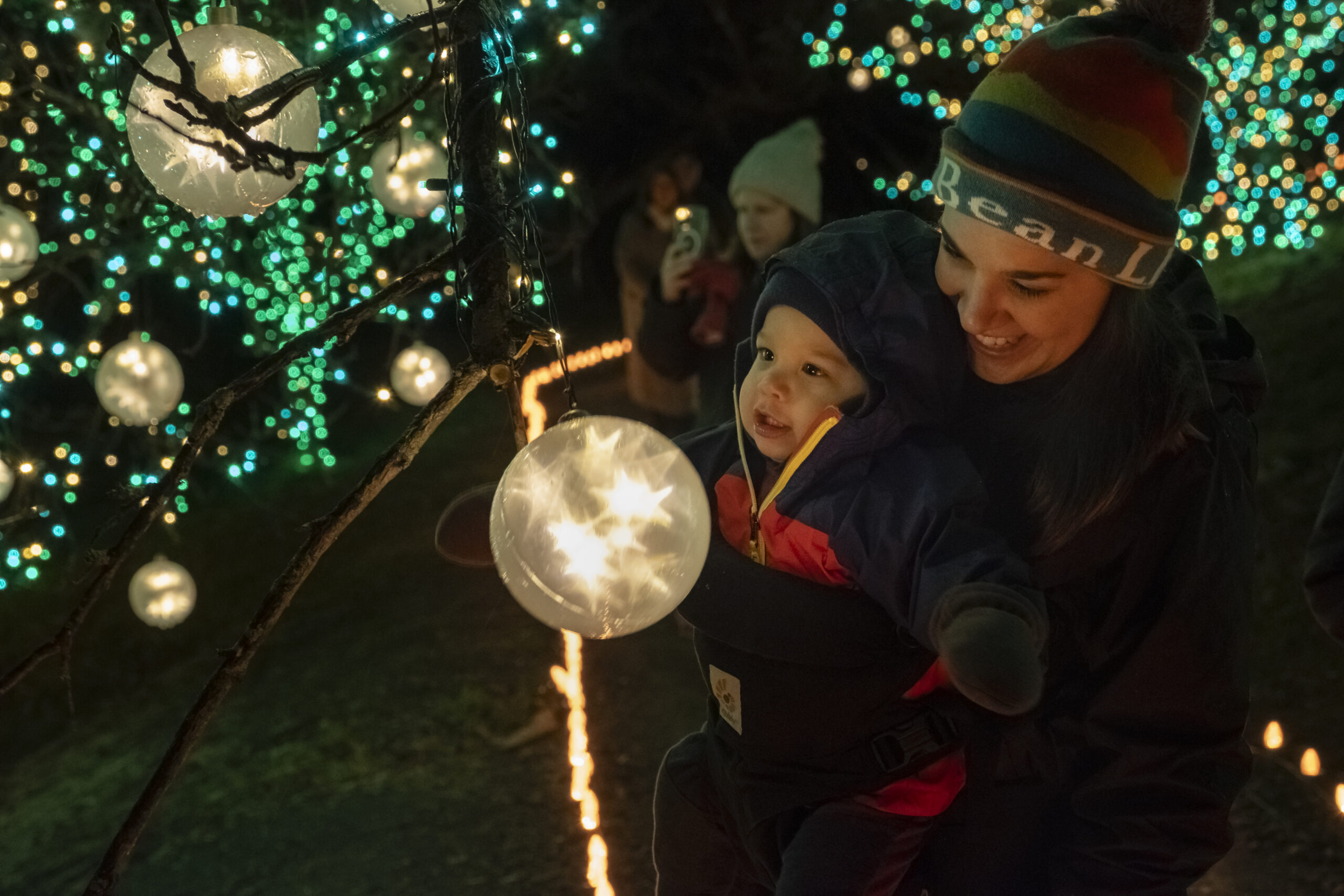 a guardian and child look at a glowing orb