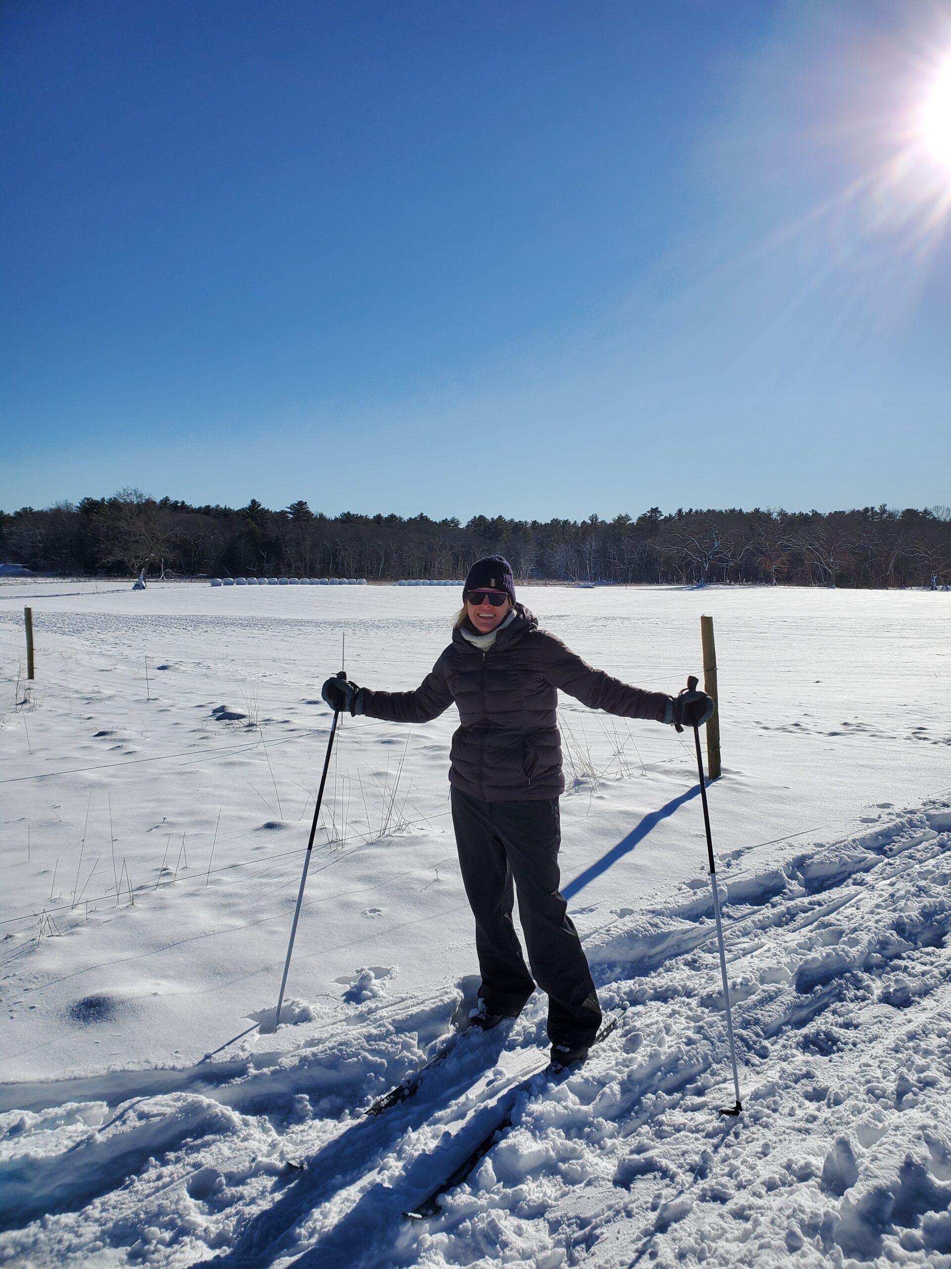 A person cross country skiing in a snowy field at Appleton Farms