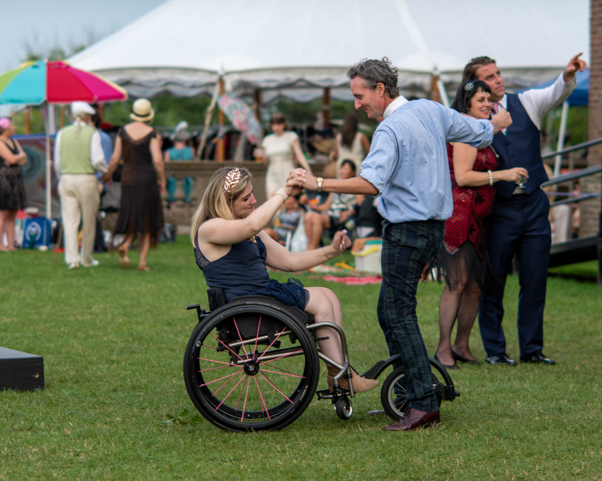 Two people dancing at a Trustees event during the day