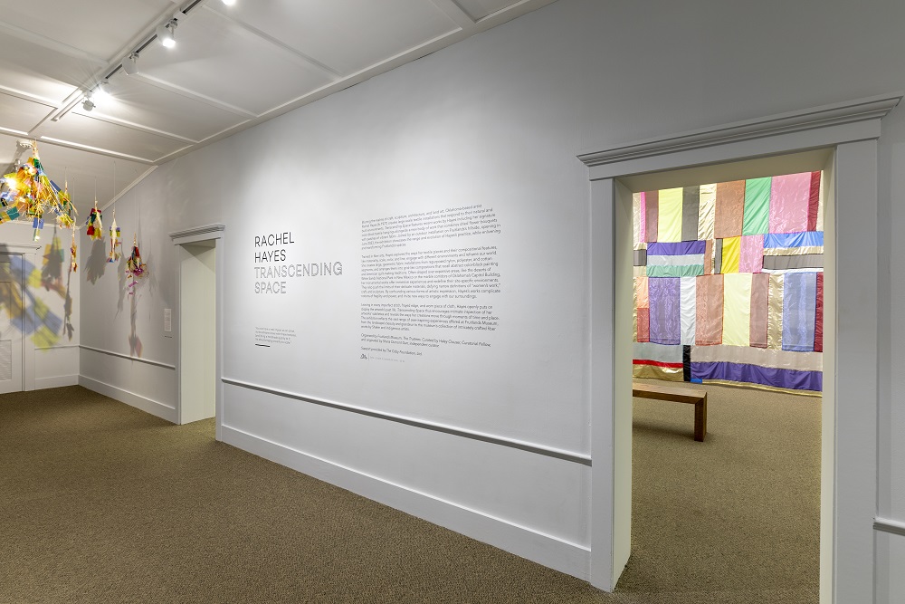 a white hallway with text on the wall and colorful banners in the background