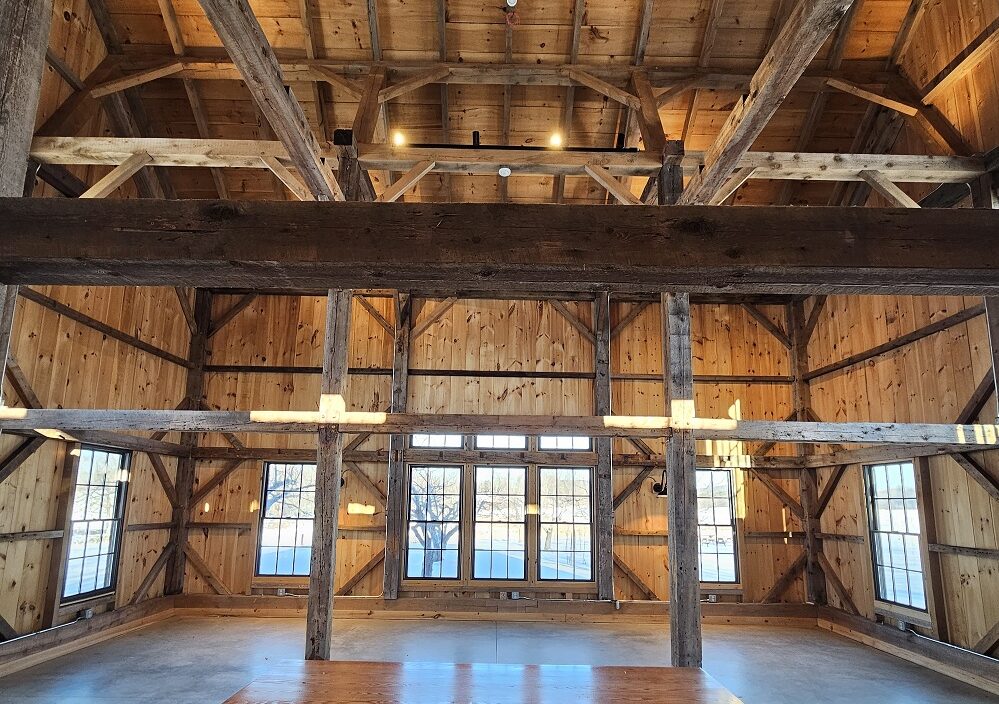 the interior of a wooden post and beam barn with a concrete floor
