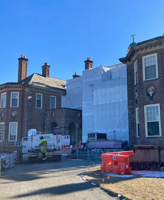 an exterior view of the Great House at Castle Hill with scaffolding and tarps being put up