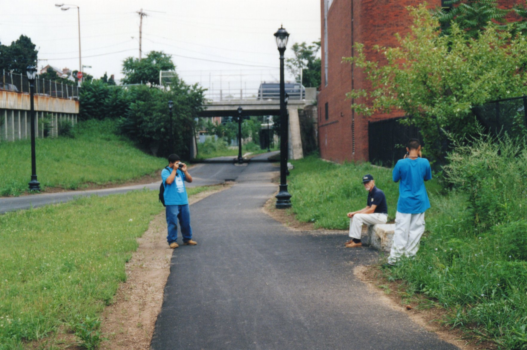 two young people take photos on the greenway
