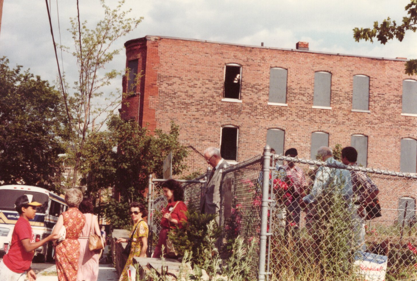 a group of people outside an abandoned building in this 1980s photo