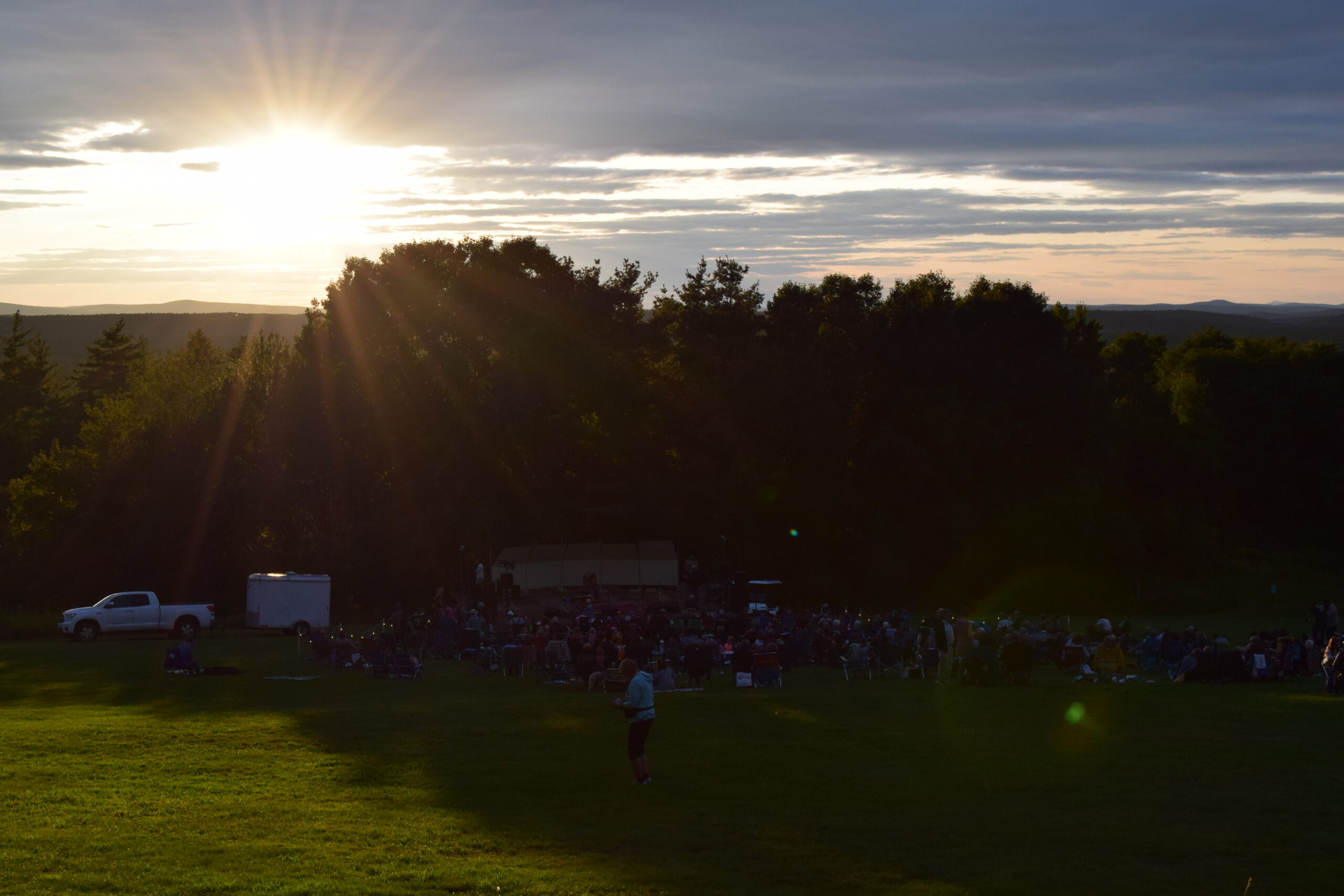 The sun sets over the trees at Fruitlands