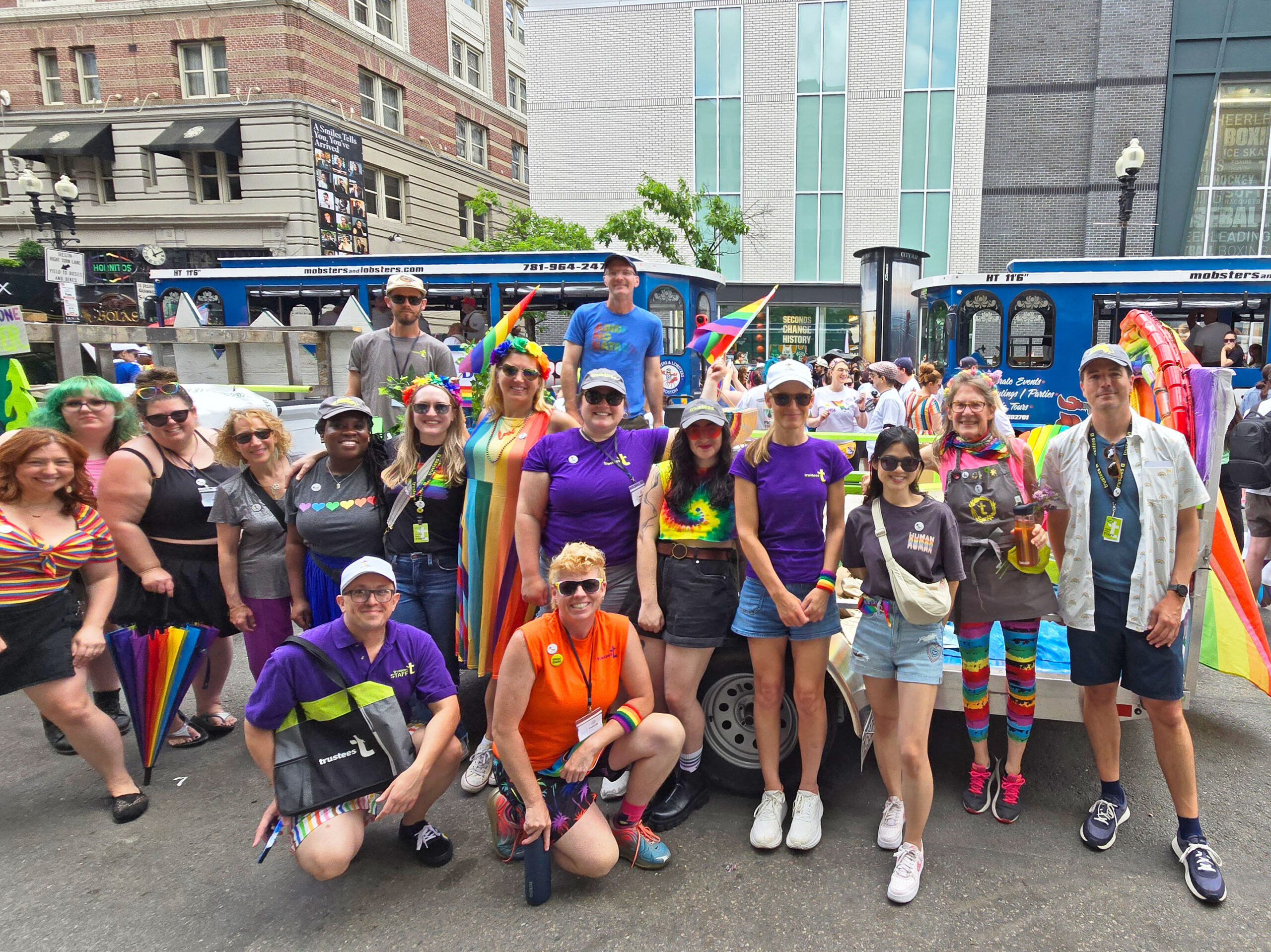 A group from The Trustees poses in front of their 2024 pride parade float