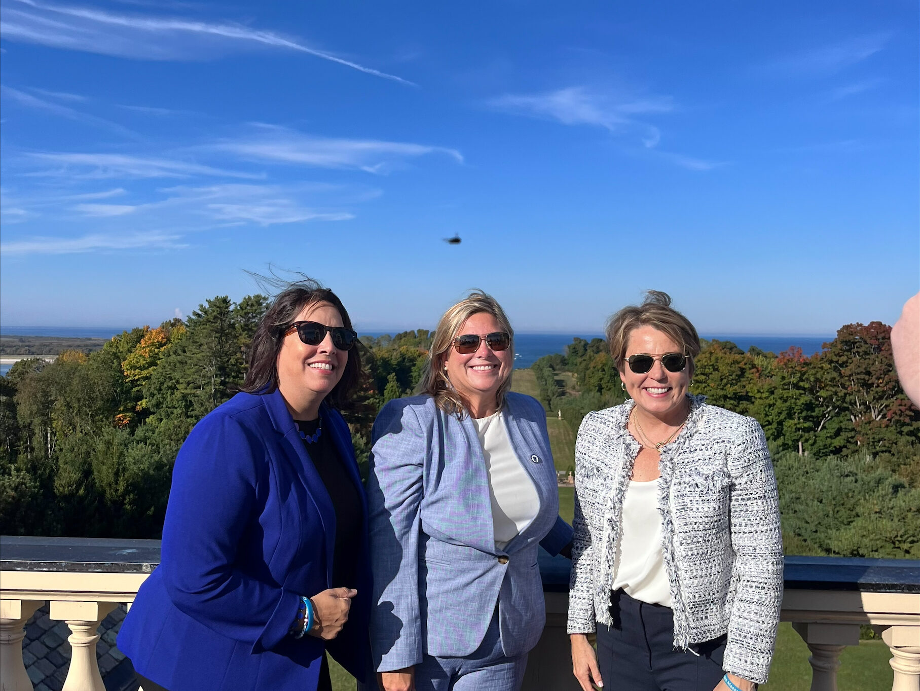 Lt. Governor Driscoll, Rep Kassner and Governor Healey pose on the roof of the Crane Estate