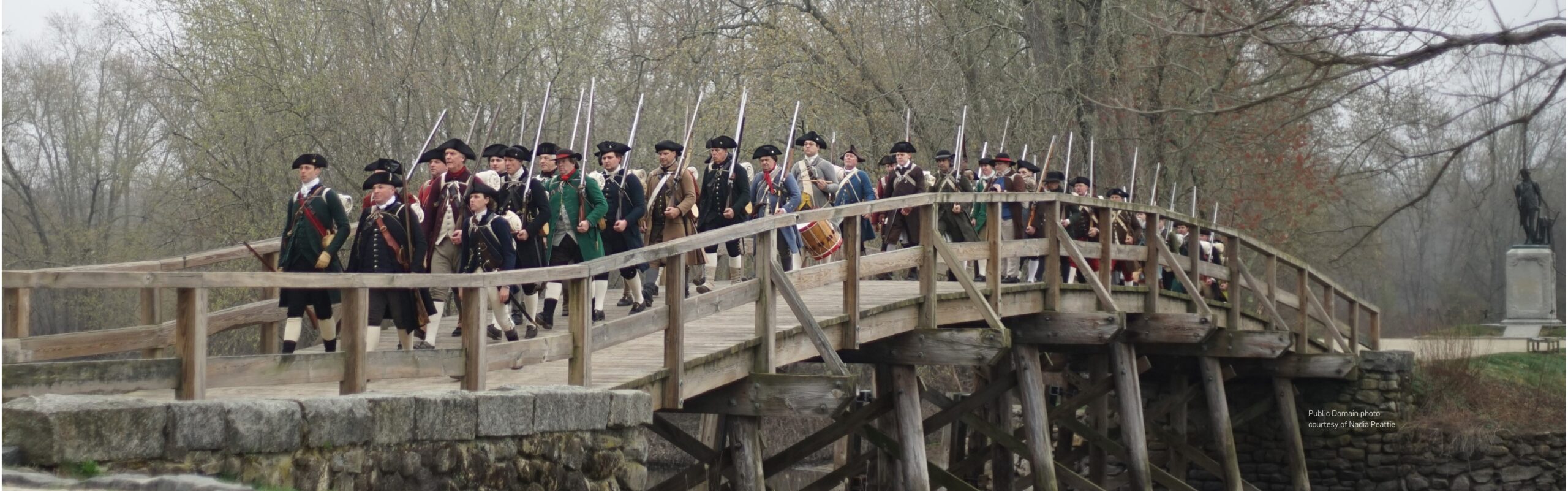 Milita walk across the Old North Bridge during a reenactment of the Battle of Concord. Public domain image courtesy of Nadia Peattie.