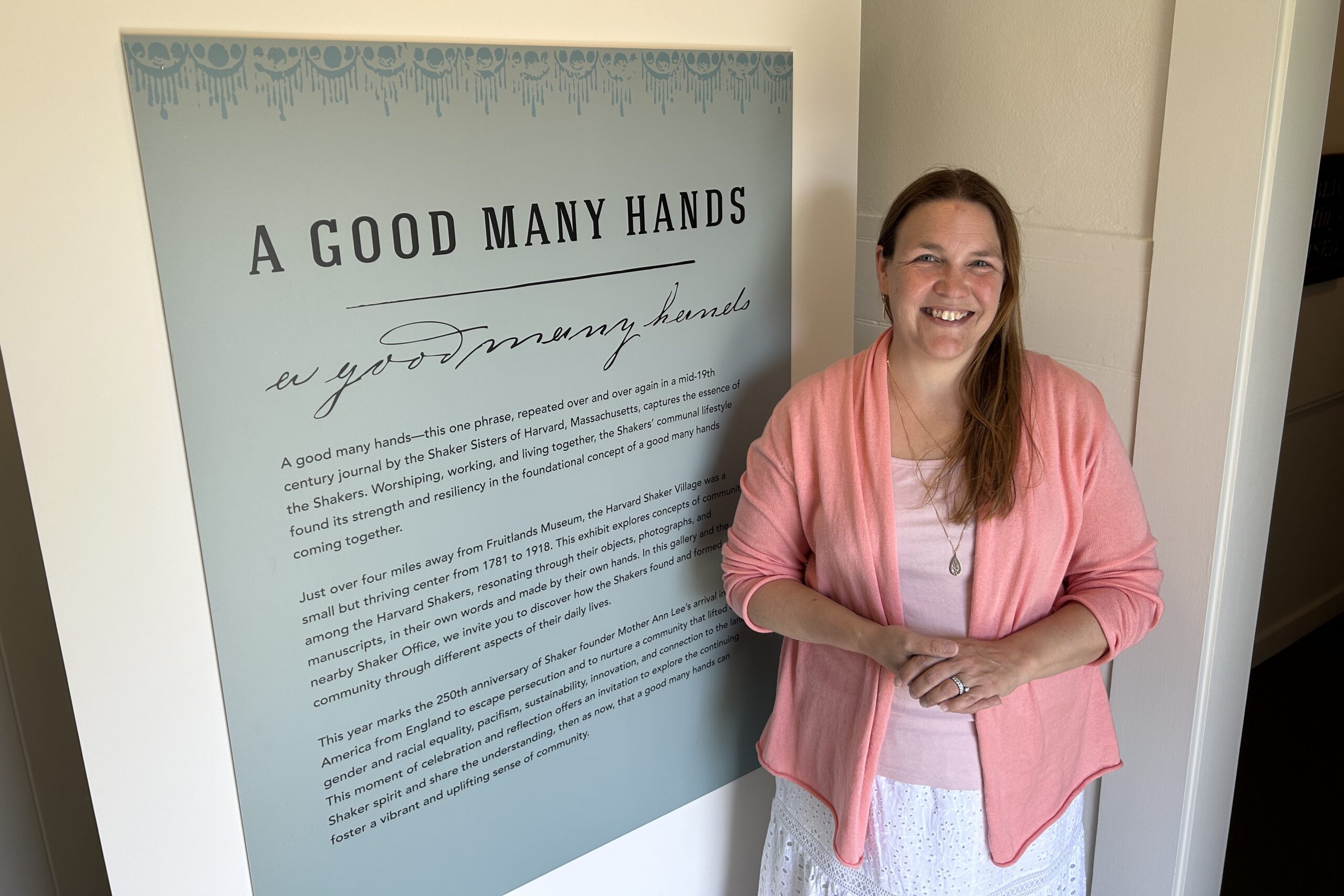 Senior Curator Christie Jackson stands in front of the welcoming sign for 