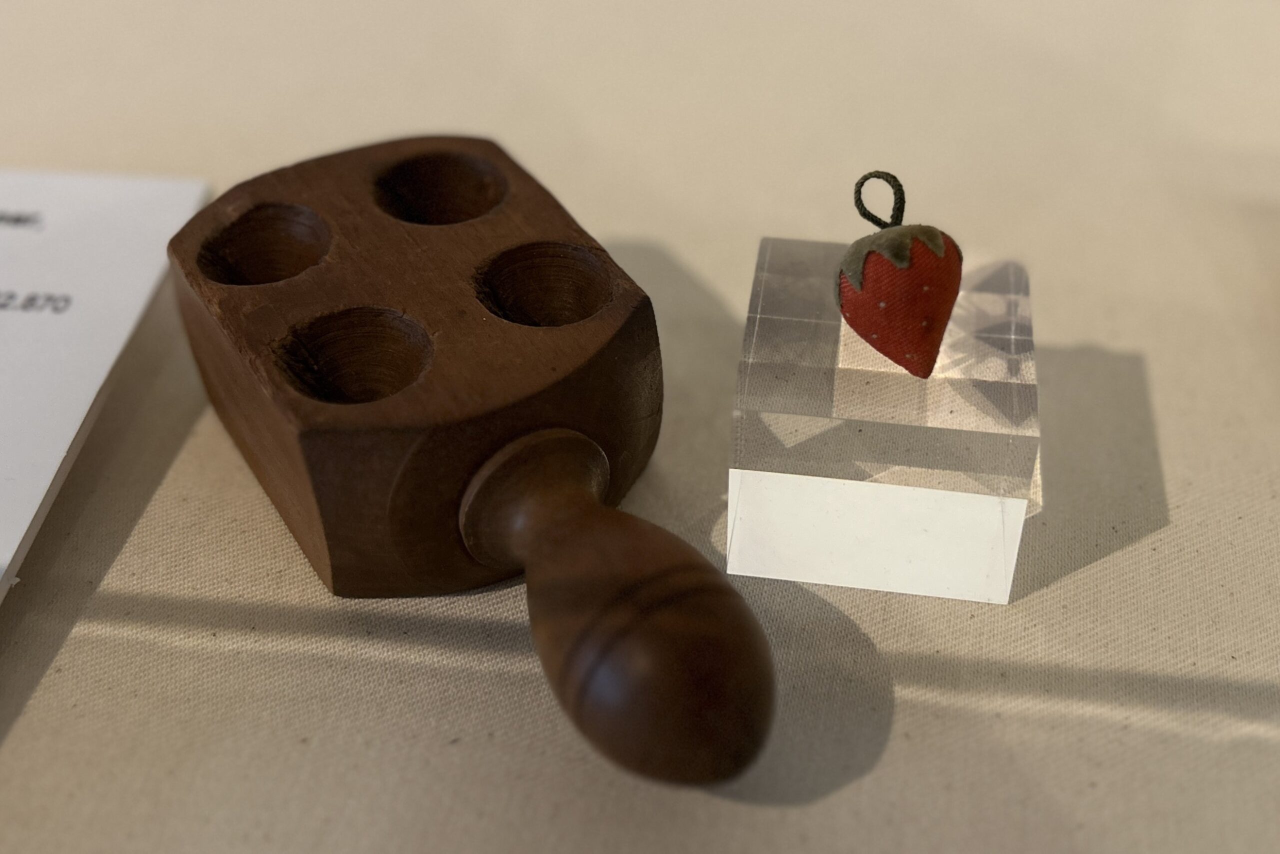 A strawberry-style needle sharpener made by the Shakers on display as part of