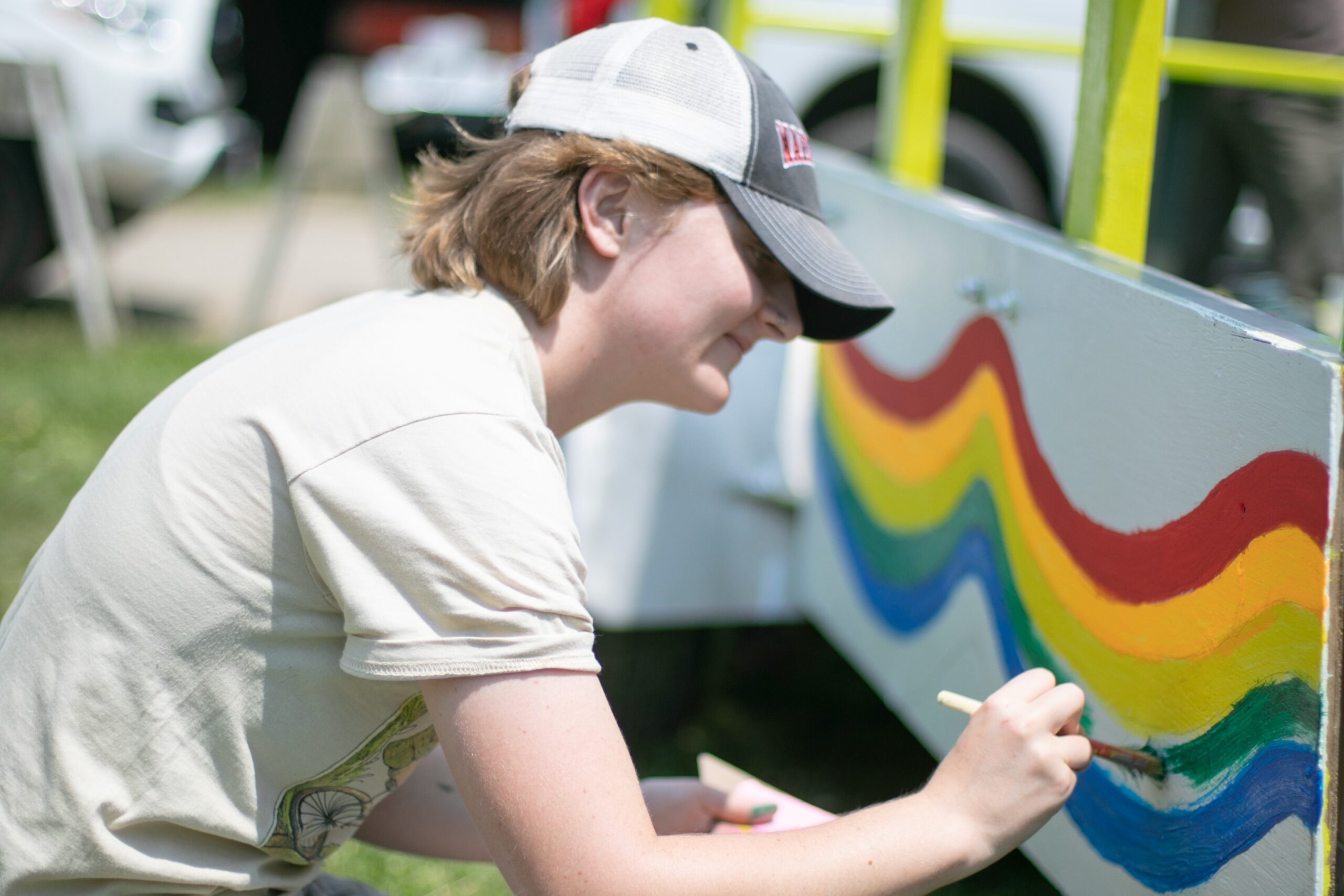 Trustees volunteer paints a Pride Parade float.