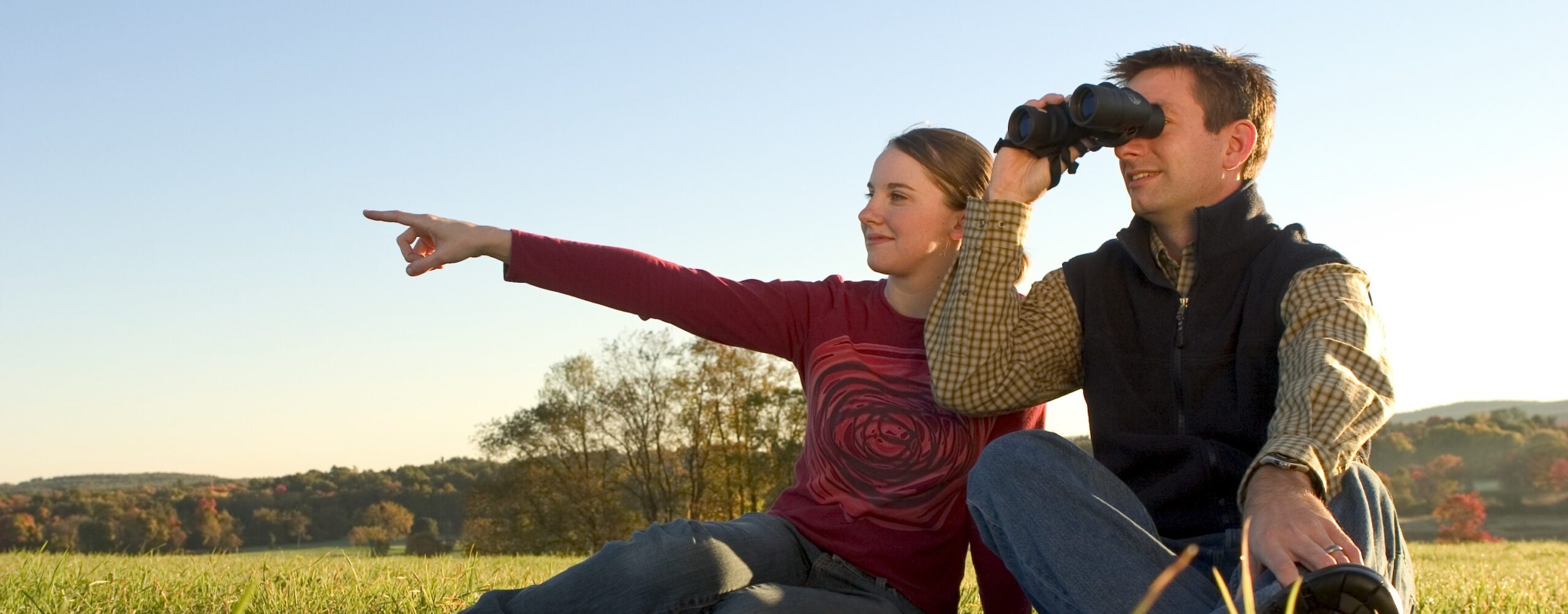 A couple uses binoculars at Dexter Drumlin Reservation.