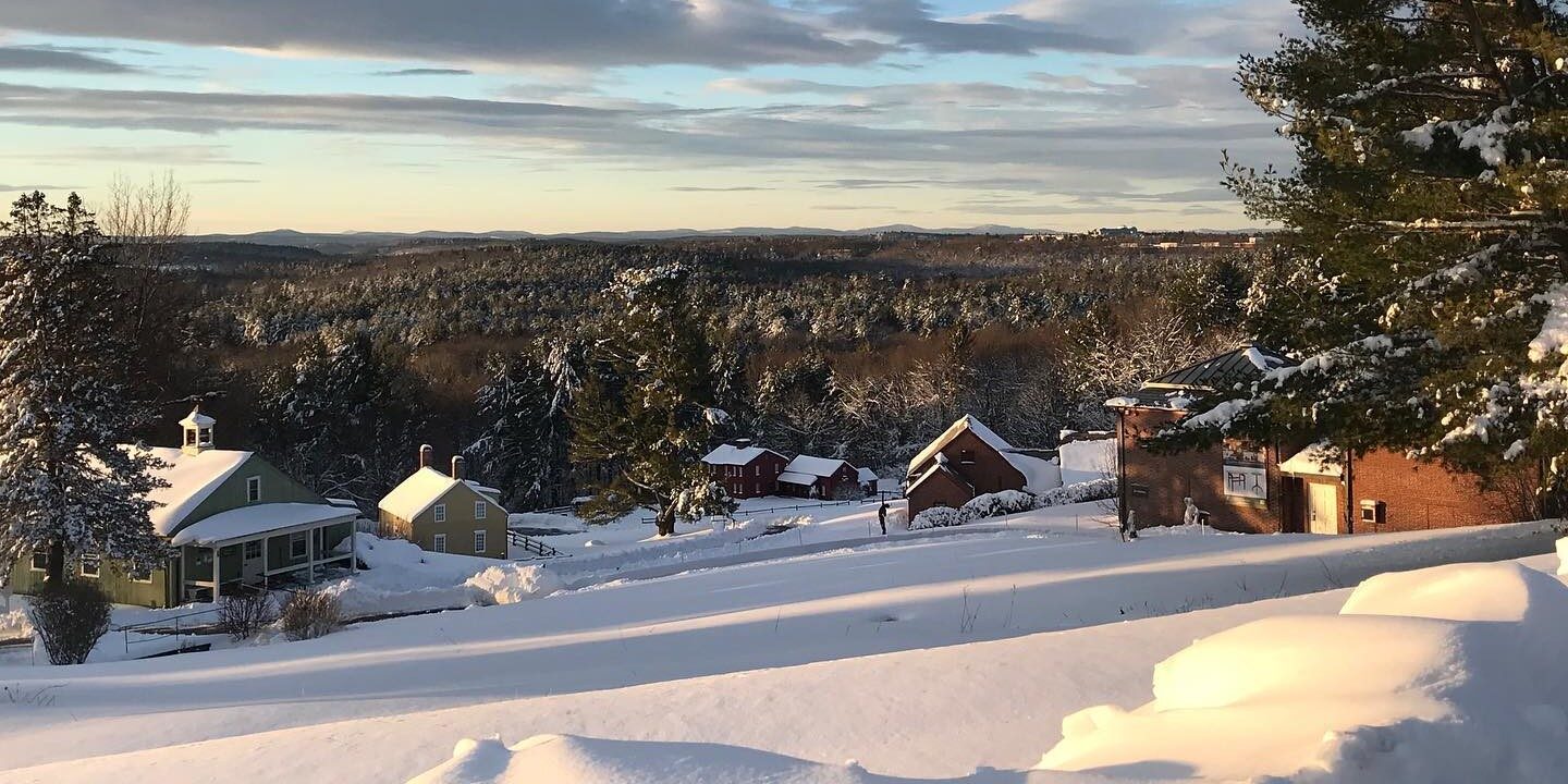 A view of several buildings at Fruitlands Museum in Harvard covered in snow