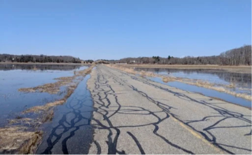 Flooding during an astronomical tide completely covers the marsh and encroaches upon Newman Road, at Old Town Hill in Newbury.