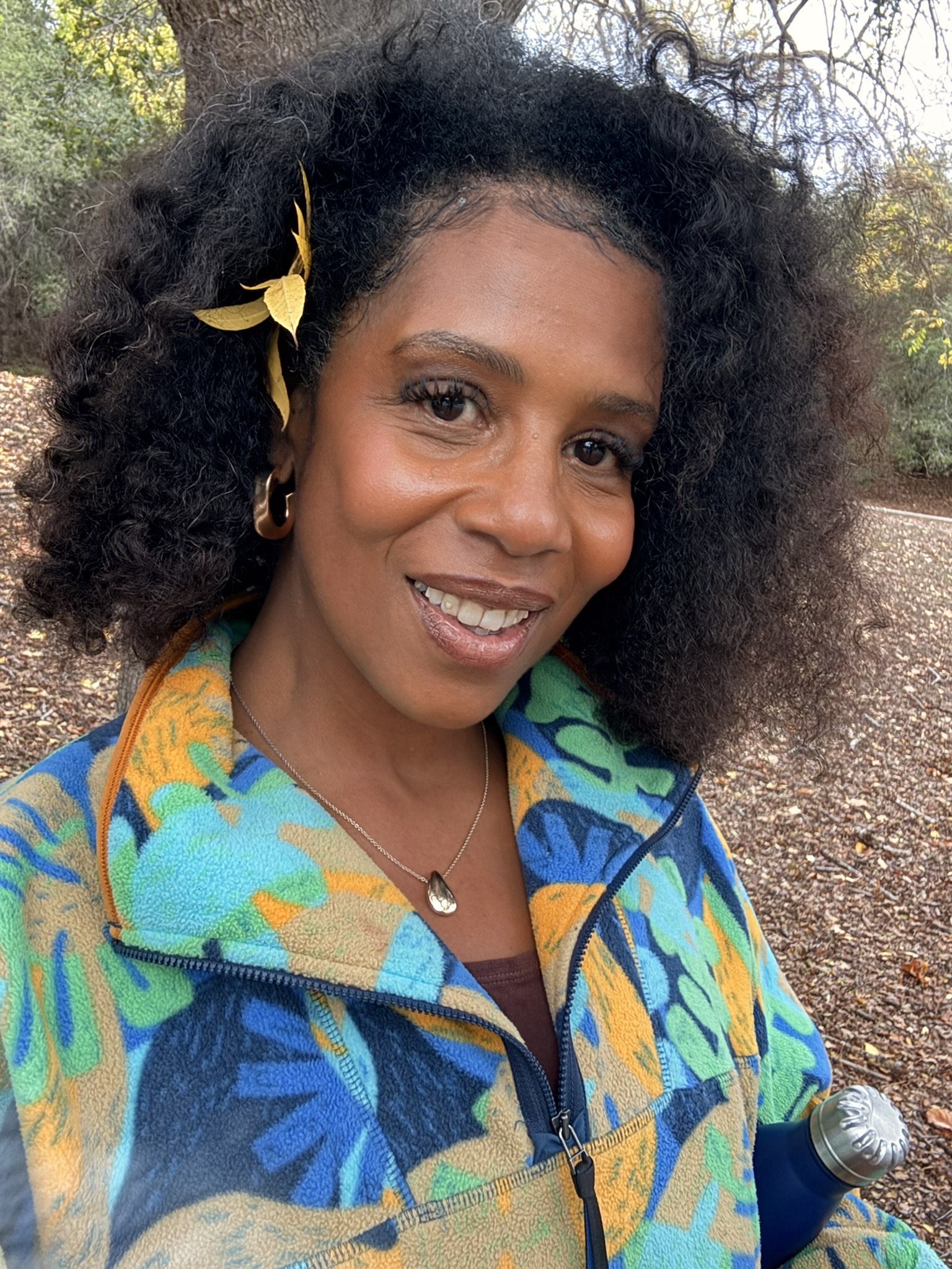 A woman in a colorful outfit smiles at the camera