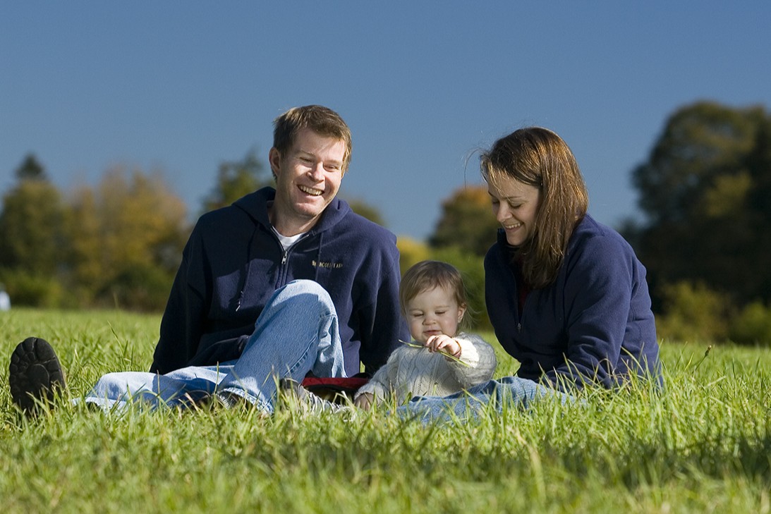 A family sits together on a lawn.