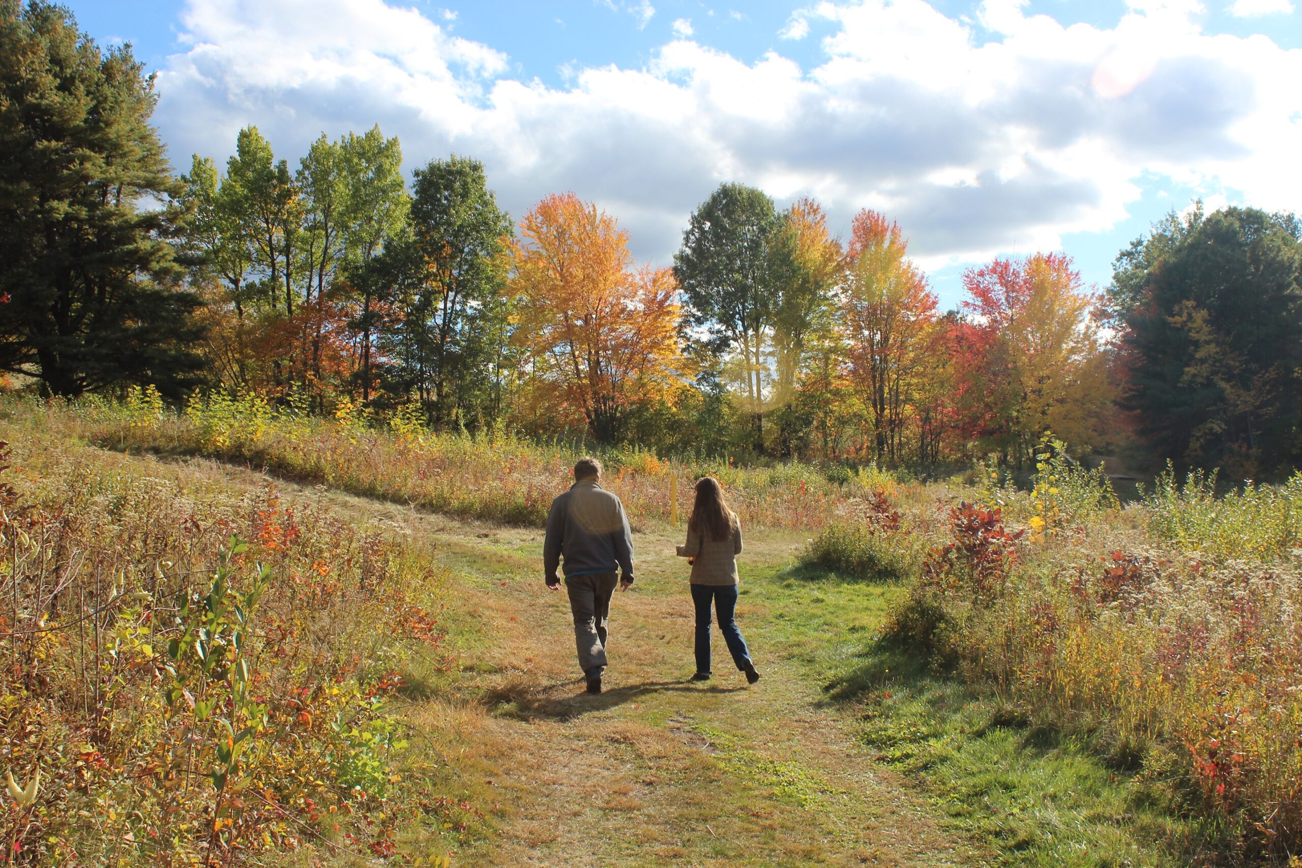 Two people hike a trail at Fruitlands Museum in Harvard during the Fall
